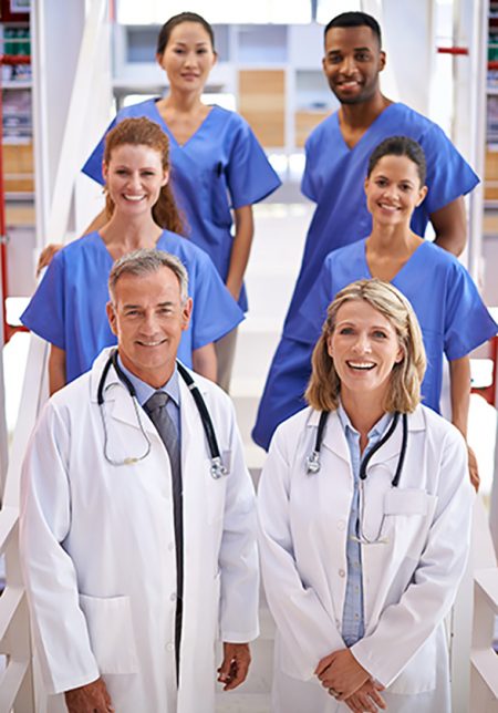 Portrait of a diverse team of medical professionals standing on a staircase in a hospital